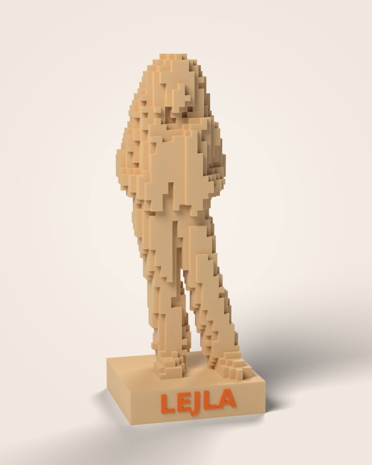 Pixel figurica djevojke složena od kockica na pješčanom postolju s imenom LEJLA